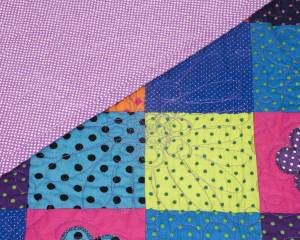 Dotty-About-You-patchwork-cot-quilt-showing-reverse.