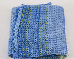 Oval-Blue-Variegated-crochet-blanket-with-frilly-edge-folded-CB106