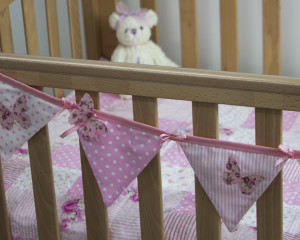Flutterby Butterfly bunting in pink on cot with Flutterby Butterfly quilt
