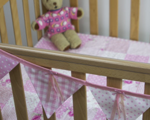 Ribbons and sequins bunting in pink on cot